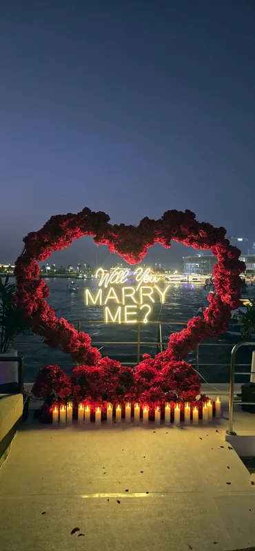 Cœur de roses rouges et pétales de roses sur le pont d’un yacht au crépuscule