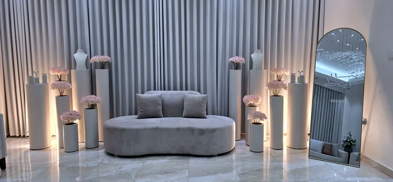 Sofa gris entre des colonnes fleuries et un miroir en arche